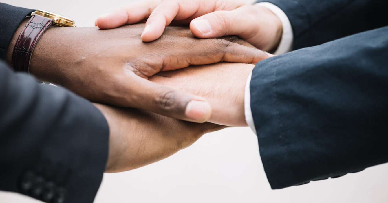 colleagues-holding-hands-together ASSETJAMENT LABORAL